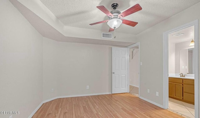 11713 Queens Garden Cir, El Paso, TX 79936 - unfurnished bedroom with a textured ceiling, light wood-style floors, and connected bathroom