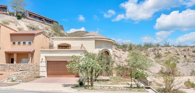 4540 N Stanton St, El Paso, TX 79902 - view of front of property with a balcony, driveway, stucco siding, and a tile roof