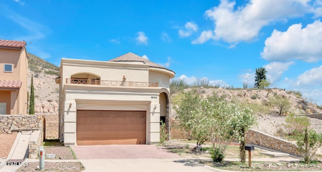 4540 N Stanton St, El Paso, TX 79902 - view of front of house with a garage, a balcony, driveway, and stucco siding