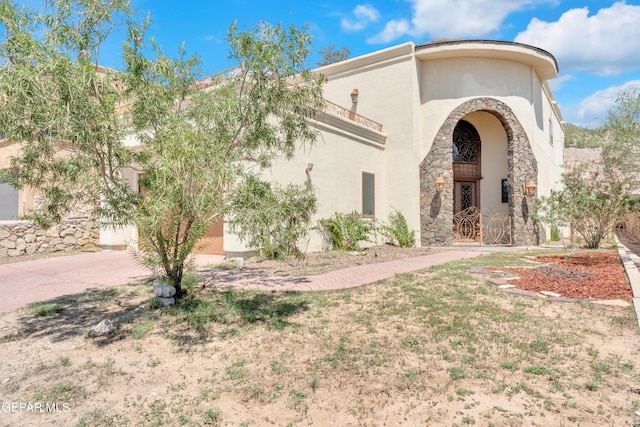 4540 N Stanton St, El Paso, TX 79902 - mediterranean / spanish home with stucco siding, a garage, stone siding, and driveway