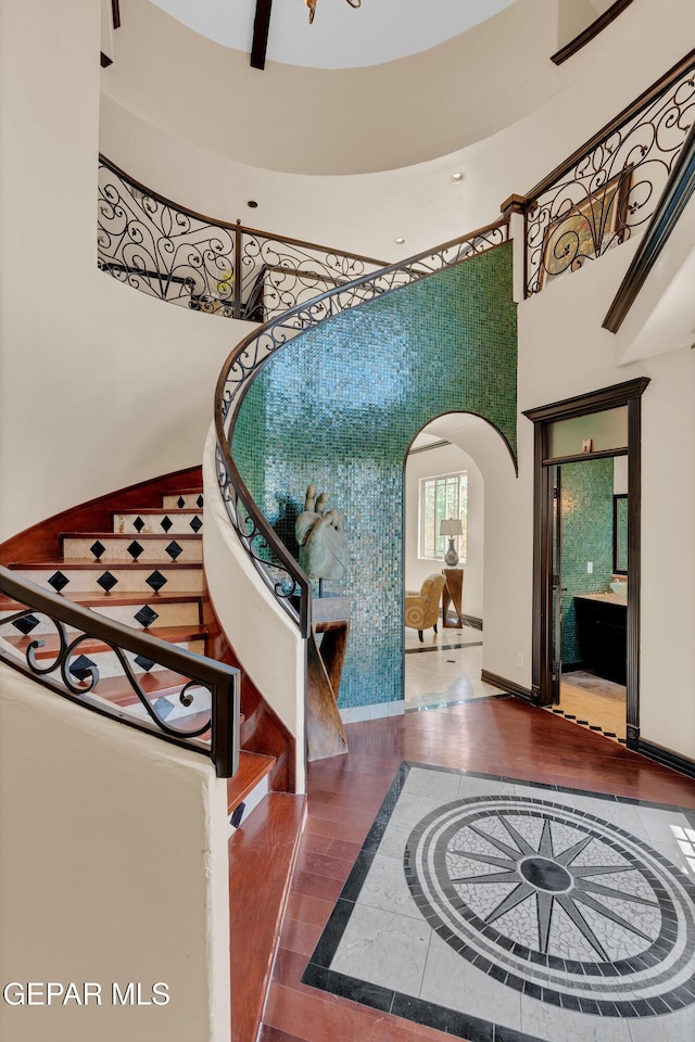 4540 N Stanton St, El Paso, TX 79902 - staircase with inlaid floor details, a high ceiling, arched walkways, recessed lighting, and wood finished floors