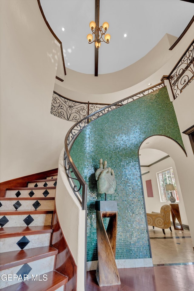 4540 N Stanton St, El Paso, TX 79902 - stairs featuring arched walkways, a towering ceiling, a chandelier, and recessed lighting