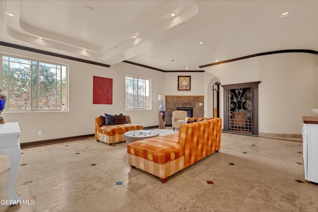 4540 N Stanton St, El Paso, TX 79902 - tiled living room featuring a tray ceiling, a tile fireplace, recessed lighting, arched walkways, and ornamental molding