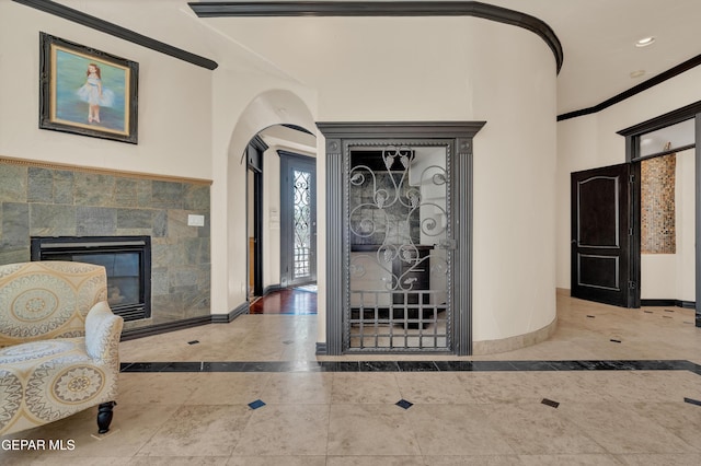 4540 N Stanton St, El Paso, TX 79902 - foyer entrance with inlaid floor details, a fireplace, arched walkways, crown molding, and recessed lighting