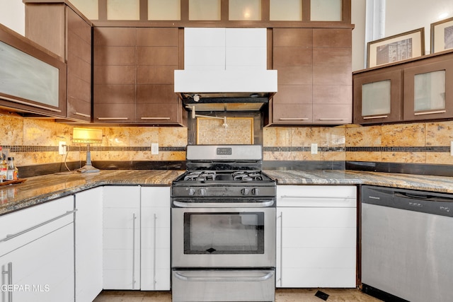 4540 N Stanton St, El Paso, TX 79902 - kitchen featuring appliances with stainless steel finishes, dark stone countertops, glass insert cabinets, and decorative backsplash