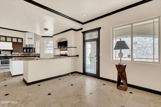 4540 N Stanton St, El Paso, TX 79902 - kitchen featuring ornamental molding, stainless steel range with gas cooktop, a peninsula, backsplash, and light tile patterned floors