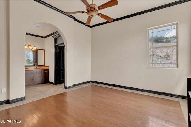 4540 N Stanton St, El Paso, TX 79902 - empty room with ornamental molding, arched walkways, light wood finished floors, and a ceiling fan