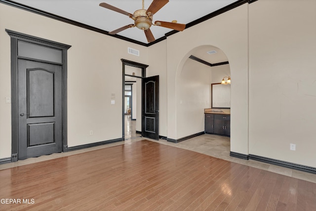 4540 N Stanton St, El Paso, TX 79902 - unfurnished room with ornamental molding, a ceiling fan, arched walkways, and light wood finished floors