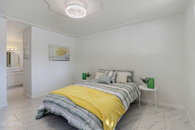 10304 Thor St, El Paso, TX 79924 - bedroom with a textured ceiling, ensuite bath, and light marble finish flooring
