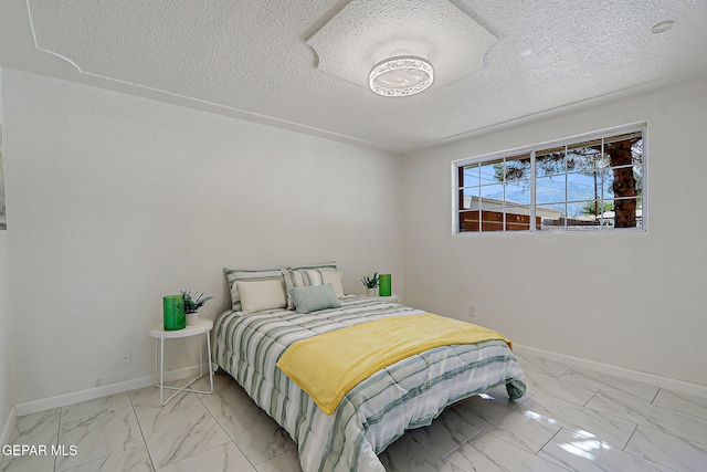 10304 Thor St, El Paso, TX 79924 - bedroom with light marble finish floors and a textured ceiling