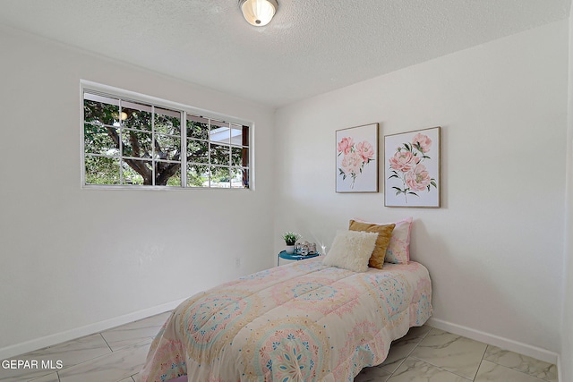 10304 Thor St, El Paso, TX 79924 - bedroom with marble look tiles and a textured ceiling