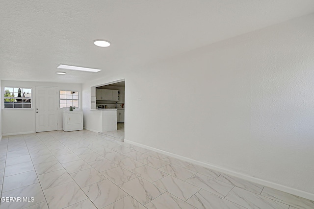 10304 Thor St, El Paso, TX 79924 - empty room with washer / clothes dryer, light marble finish flooring, and a textured ceiling