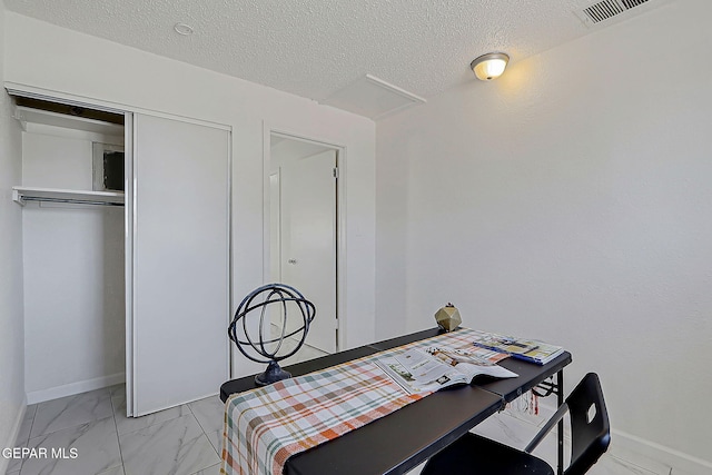 10304 Thor St, El Paso, TX 79924 - bedroom featuring light marble finish flooring, a closet, a textured ceiling, and attic access
