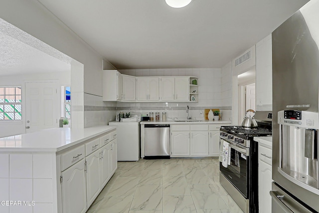10304 Thor St, El Paso, TX 79924 - kitchen with stainless steel appliances, washer / clothes dryer, light countertops, open shelves, and white cabinetry