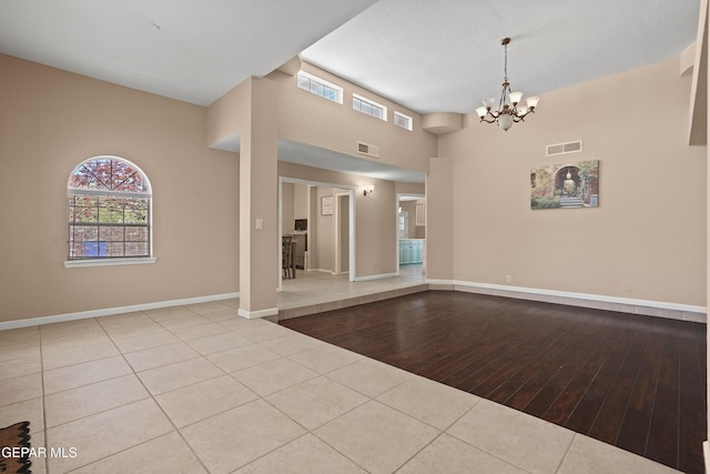 2072 Pueblo Nuevo Cir, El Paso, TX 79936 - unfurnished living room with wood finished floors, a chandelier, and a high ceiling