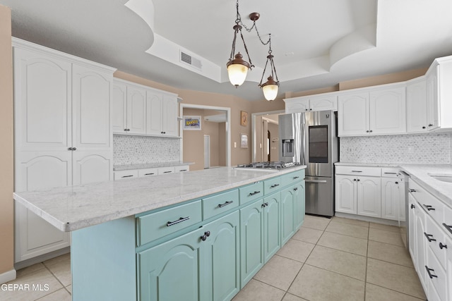 2072 Pueblo Nuevo Cir, El Paso, TX 79936 - kitchen with stainless steel appliances, blue cabinetry, light tile patterned floors, a kitchen island, and tasteful backsplash