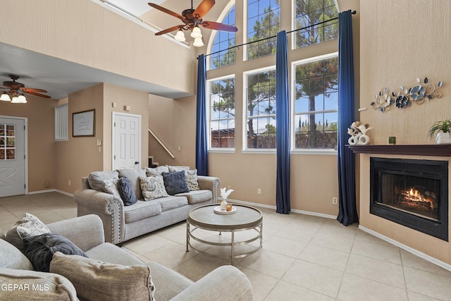 2072 Pueblo Nuevo Cir, El Paso, TX 79936 - living area with a ceiling fan, light tile patterned floors, a high ceiling, and a glass covered fireplace