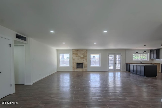 1605 Larry Wadkins Dr, El Paso, TX 79936 - unfurnished living room featuring recessed lighting, wood tiled floors, and a fireplace