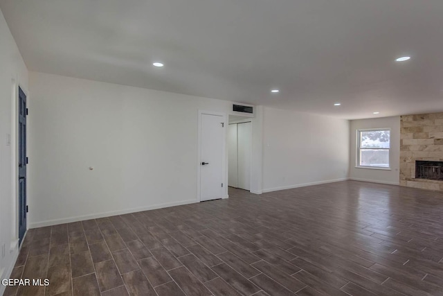 1605 Larry Wadkins Dr, El Paso, TX 79936 - unfurnished living room featuring dark wood-style floors, recessed lighting, and a stone fireplace