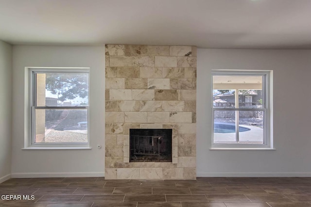 1605 Larry Wadkins Dr, El Paso, TX 79936 - unfurnished living room with wood finish floors, healthy amount of natural light, and a tile fireplace