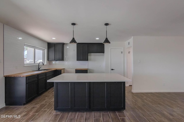 1605 Larry Wadkins Dr, El Paso, TX 79936 - kitchen with wood finished floors, decorative backsplash, recessed lighting, hanging light fixtures, and a center island