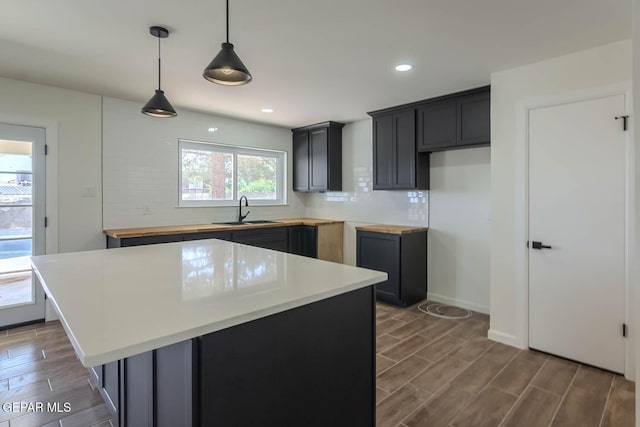 1605 Larry Wadkins Dr, El Paso, TX 79936 - kitchen with decorative backsplash, wood finished floors, recessed lighting, a center island, and pendant lighting