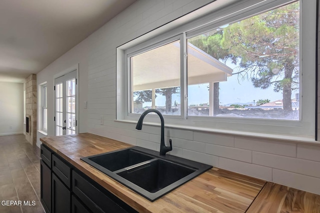 1605 Larry Wadkins Dr, El Paso, TX 79936 - kitchen with wood counters, plenty of natural light, wood finished floors, and dark cabinets