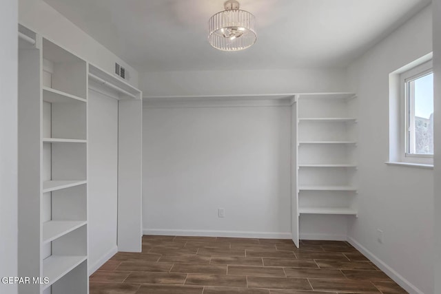 1605 Larry Wadkins Dr, El Paso, TX 79936 - spacious closet with dark wood-style floors and a chandelier