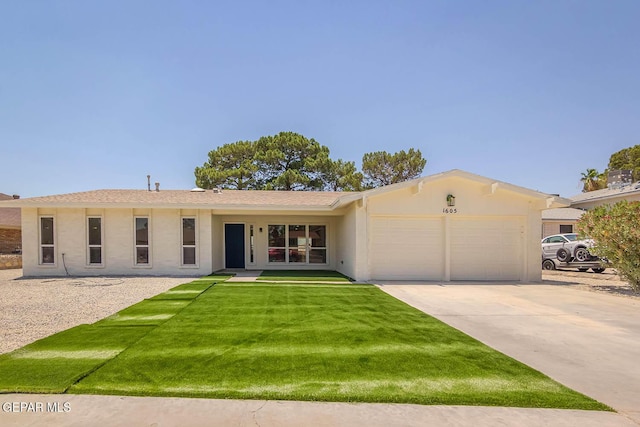 1605 Larry Wadkins Dr, El Paso, TX 79936 - single story home featuring a garage, concrete driveway, stucco siding, and a front lawn