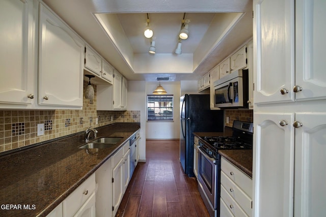 417 Irondale Dr Unit M, El Paso, TX 79912 - kitchen featuring appliances with stainless steel finishes, a raised ceiling, white cabinets, dark wood-type flooring, and decorative backsplash