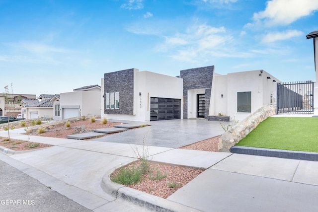 7549 Enchanted Park Dr 706849, El Paso, TX 79911 - contemporary house featuring driveway, a garage, stucco siding, stone siding, and a residential view
