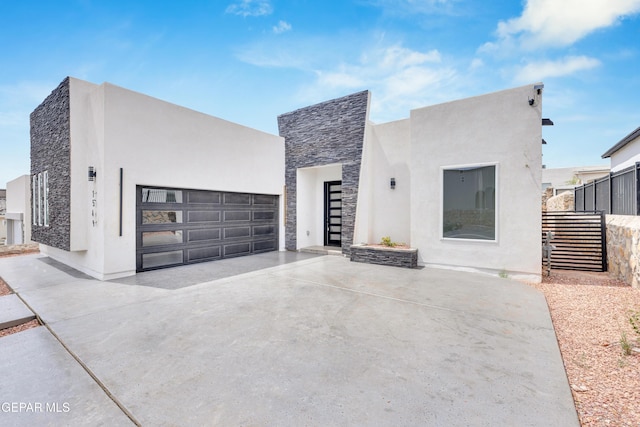 7549 Enchanted Park Dr 706849, El Paso, TX 79911 - modern home featuring stone siding, a garage, driveway, and stucco siding