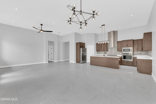 7549 Enchanted Park Dr 706849, El Paso, TX 79911 - kitchen with stainless steel appliances, open floor plan, wall chimney exhaust hood, tasteful backsplash, and an island with sink