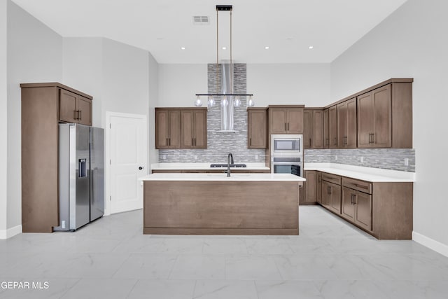 7549 Enchanted Park Dr 706849, El Paso, TX 79911 - kitchen with stainless steel appliances, light marble finish flooring, light countertops, tasteful backsplash, and a towering ceiling