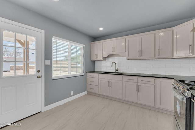 224 Ben Swain Dr, El Paso, TX 79915 - kitchen featuring stainless steel stove, backsplash, dark countertops, recessed lighting, and light marble finish flooring