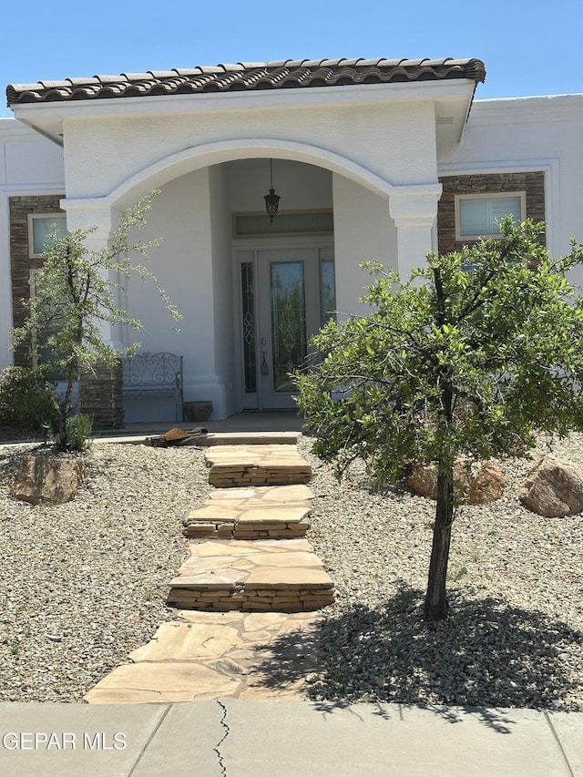 6688 Tuscany Ridge Dr, El Paso, TX 79912 - entrance to property with a tile roof, a porch, and stucco siding
