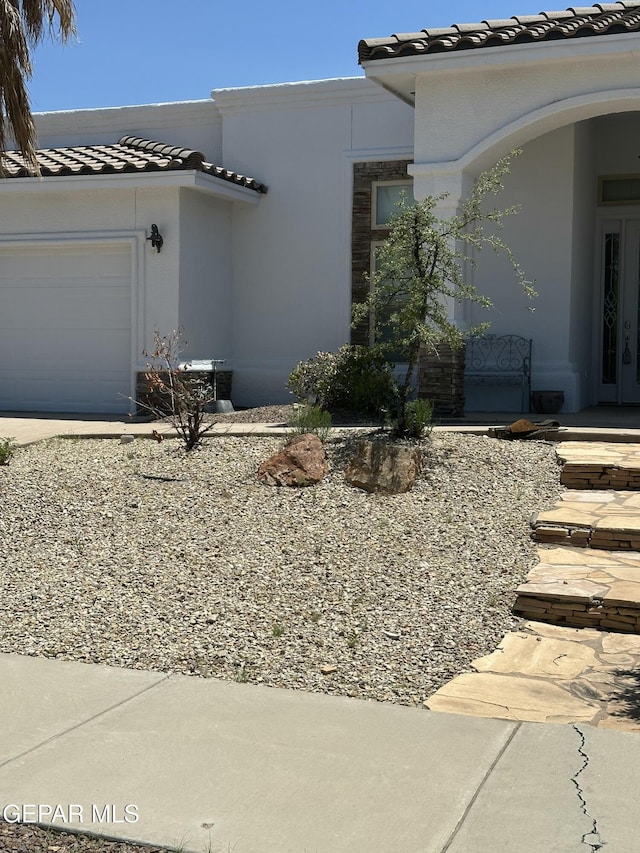6688 Tuscany Ridge Dr, El Paso, TX 79912 - view of front of property with a tile roof, stucco siding, an attached garage, and driveway