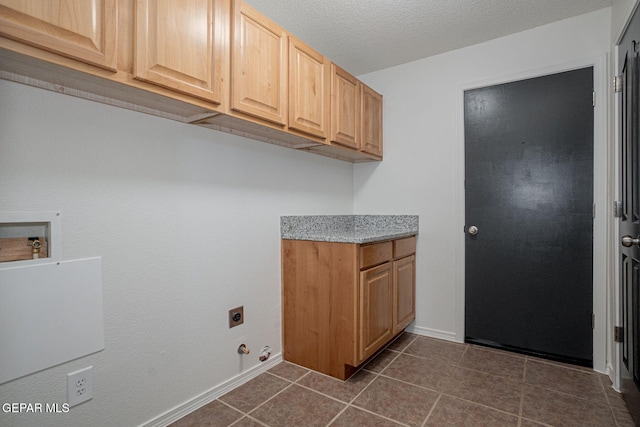 448 Ghost Flower St, Horizon City, TX 79928 - laundry room with electric dryer hookup, cabinet space, dark tile patterned flooring, and washer hookup