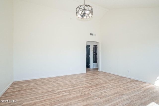448 Ghost Flower St, Horizon City, TX 79928 - empty room featuring arched walkways, light wood-type flooring, high vaulted ceiling, and a chandelier