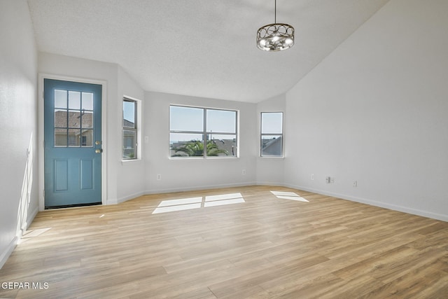 448 Ghost Flower St, Horizon City, TX 79928 - entrance foyer with lofted ceiling, a chandelier, and light wood-style floors