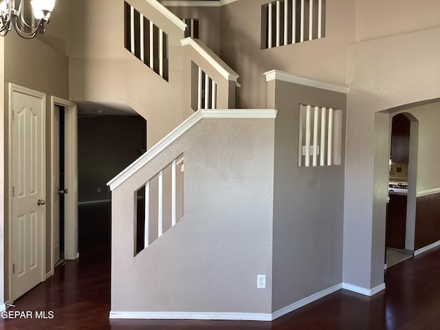 683 Juan Munoz Ct, El Paso, TX 79932 - staircase with arched walkways, wood finished floors, a chandelier, and a high ceiling