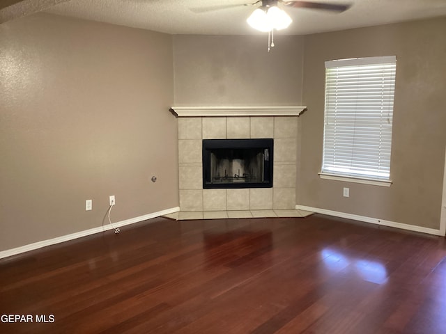 683 Juan Munoz Ct, El Paso, TX 79932 - unfurnished living room with wood finished floors, a ceiling fan, and a tiled fireplace