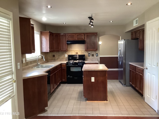 683 Juan Munoz Ct, El Paso, TX 79932 - kitchen featuring black appliances, under cabinet range hood, light countertops, arched walkways, and a center island