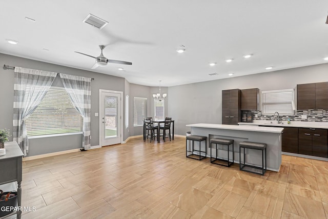 13594 Gatton St, El Paso, TX 79928 - kitchen with modern cabinets, light countertops, a center island, dark brown cabinetry, and a breakfast bar area