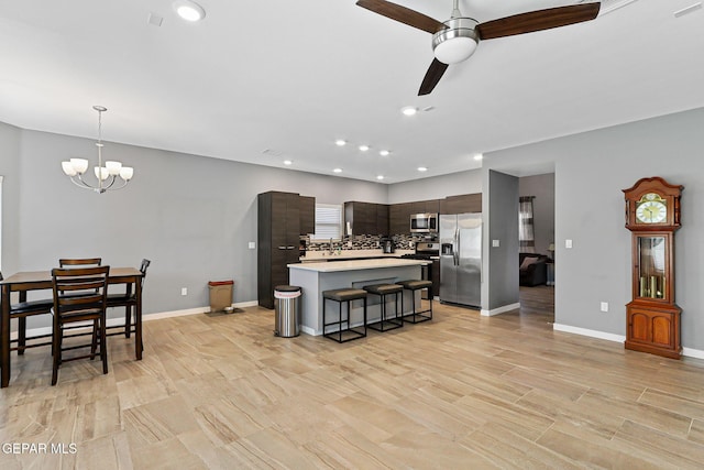 13594 Gatton St, El Paso, TX 79928 - kitchen with stainless steel appliances, light countertops, ceiling fan, a chandelier, and a breakfast bar