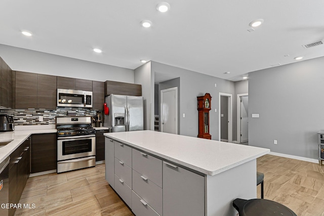 13594 Gatton St, El Paso, TX 79928 - kitchen featuring appliances with stainless steel finishes, light countertops, a center island, tasteful backsplash, and modern cabinets