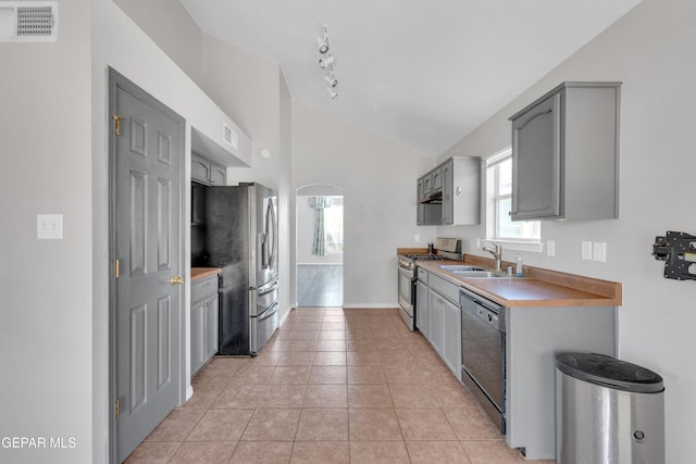 11905 Jim Webb Dr, El Paso, TX 79934 - kitchen featuring stainless steel appliances, gray cabinetry, lofted ceiling, light tile patterned floors, and light countertops