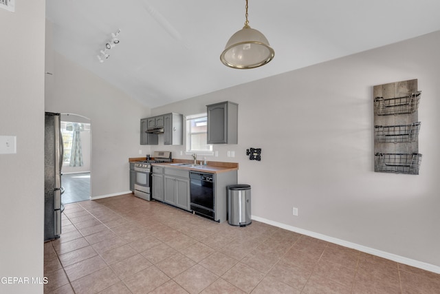 11905 Jim Webb Dr, El Paso, TX 79934 - kitchen with stainless steel appliances, gray cabinetry, light tile patterned floors, lofted ceiling, and under cabinet range hood