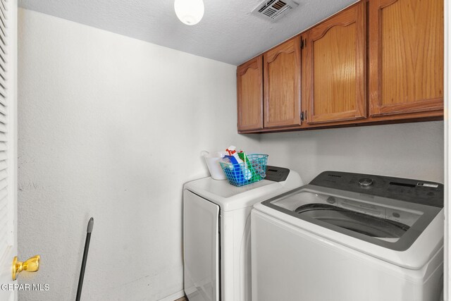 12090 Sterling Mary Way, El Paso, TX 79936 - laundry area featuring cabinet space, washer and clothes dryer, and a textured ceiling