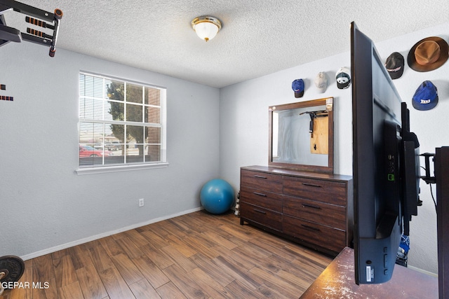12090 Sterling Mary Way, El Paso, TX 79936 - workout area with wood finished floors and a textured ceiling